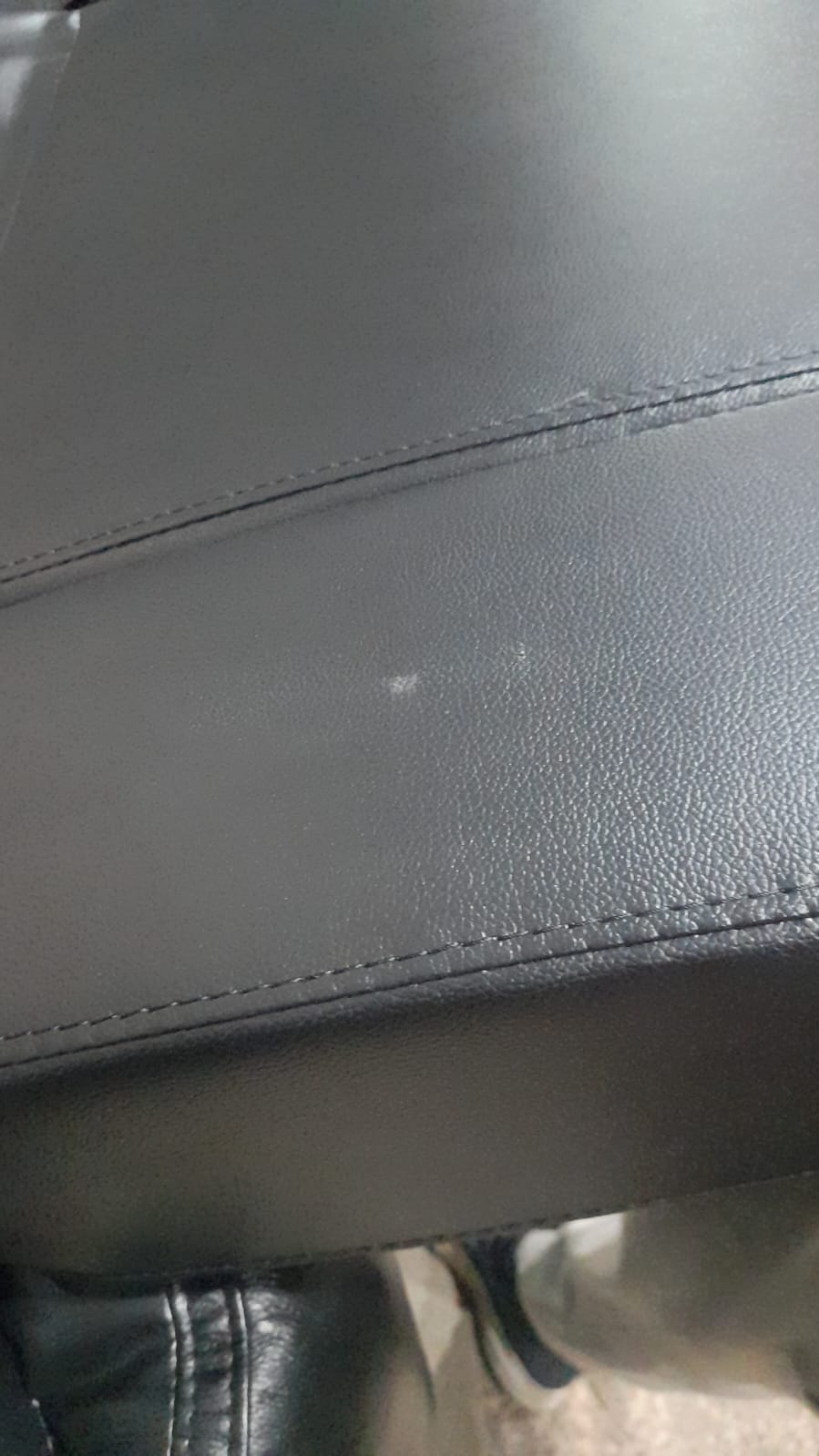 Close-up of a gray leather seat with visible stitching