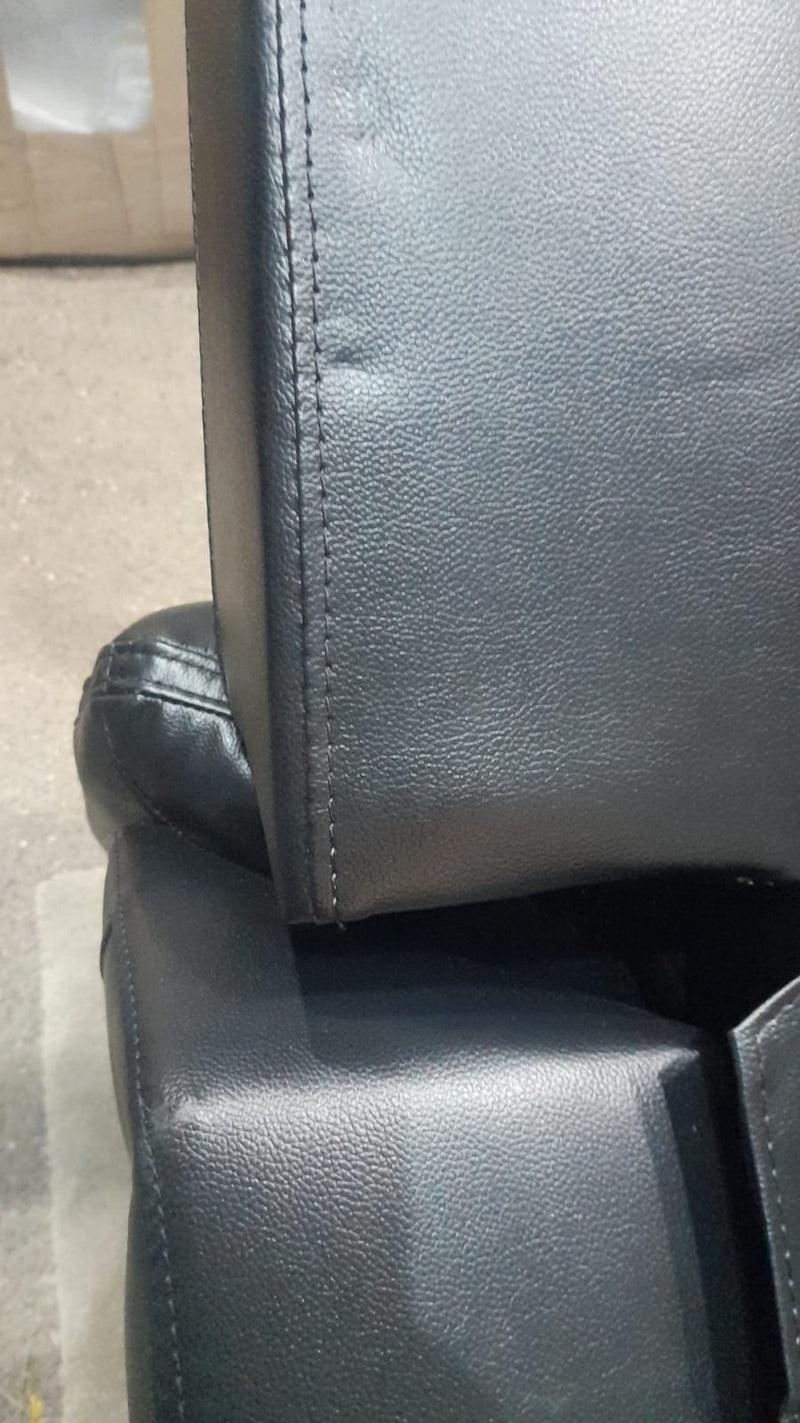 Close-up of a black leather seat with visible stitching on a vehicle.