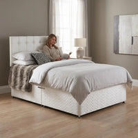 white fabrc bed in a room setting 