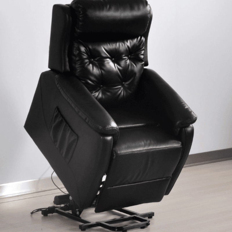 Black leather recliner chair against a white wall