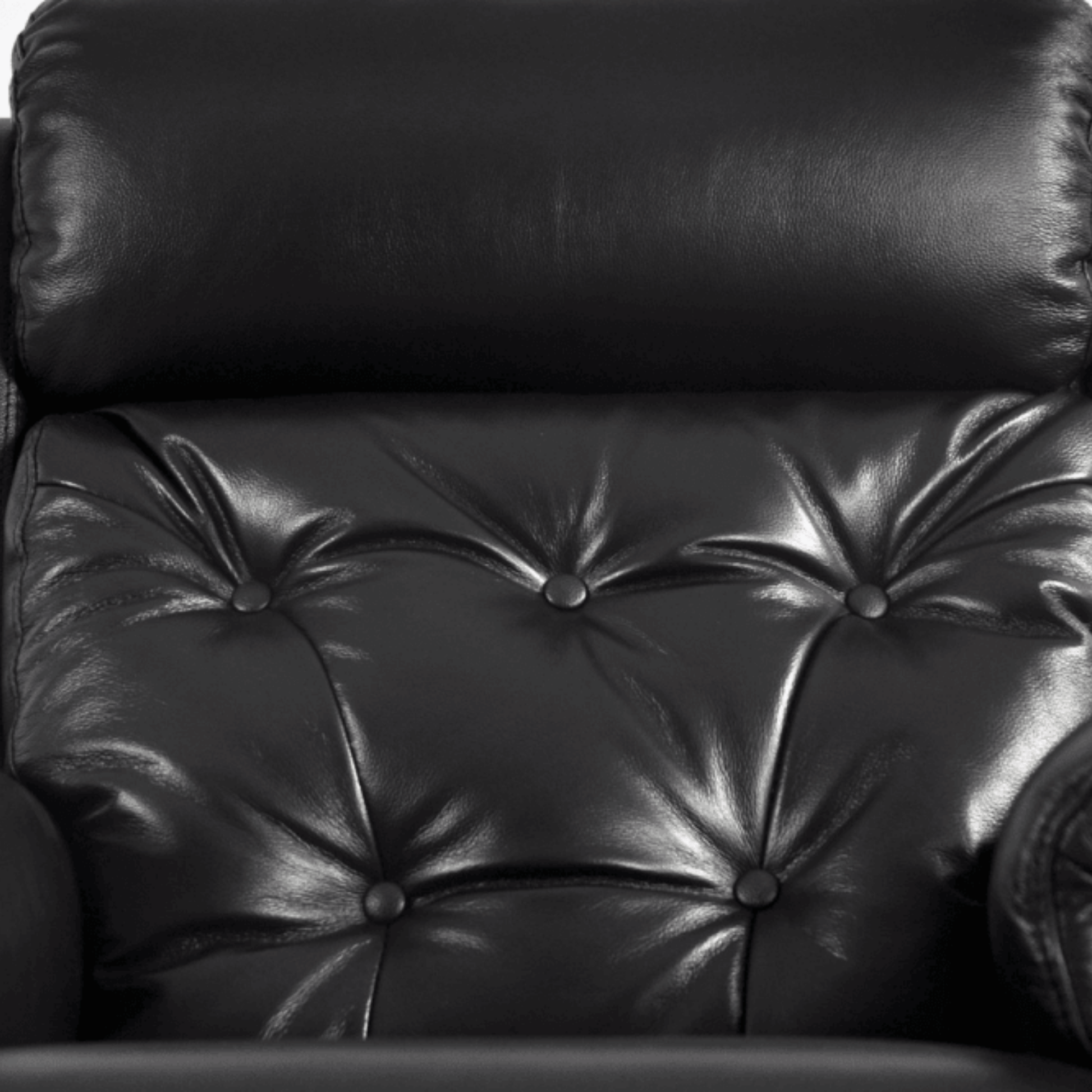 Close-up of a black leather armchair with buttoned backrest