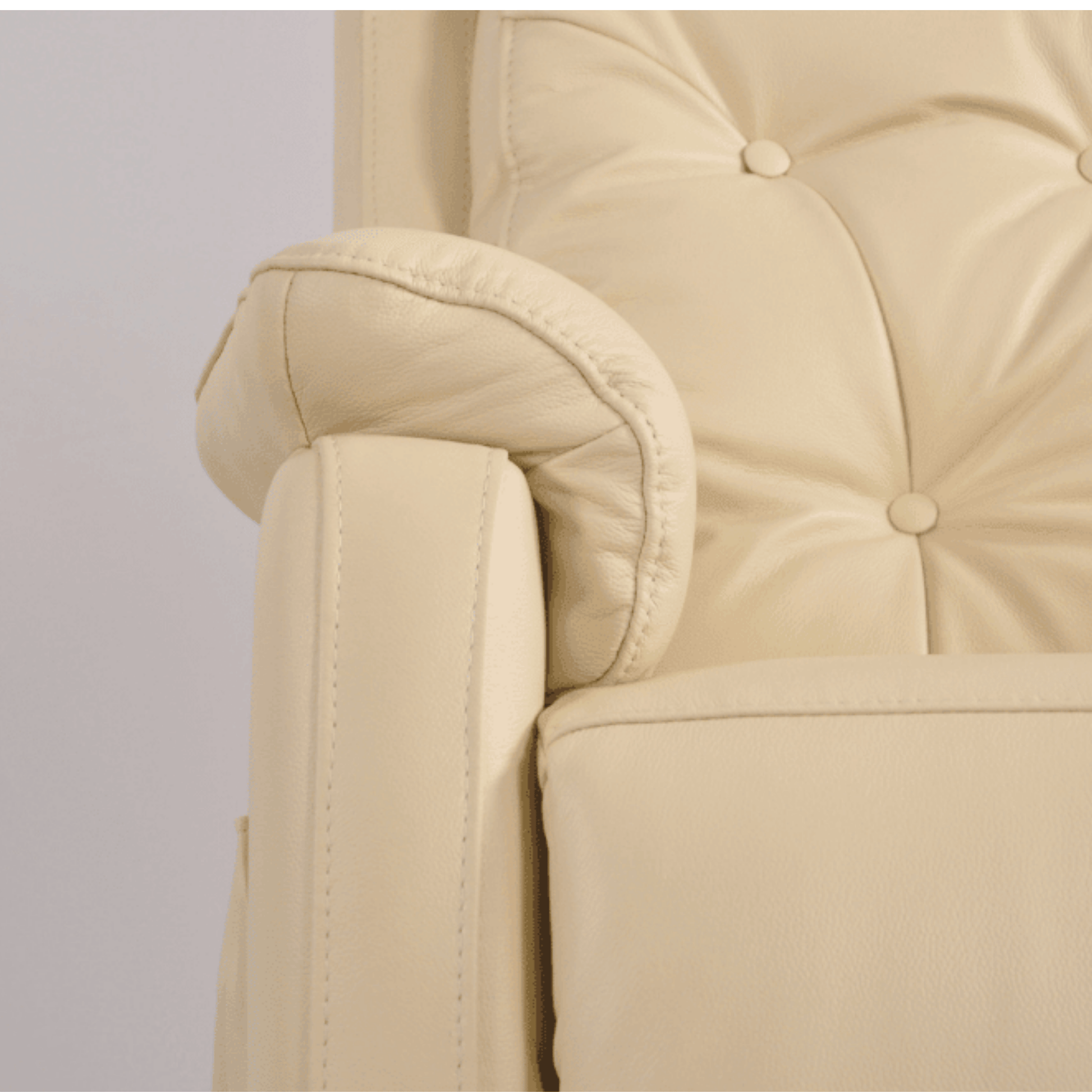 Close-up of a beige armchair with buttoned backrest on a light gray background