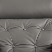 Gray tufted cushion with button details on a plain background