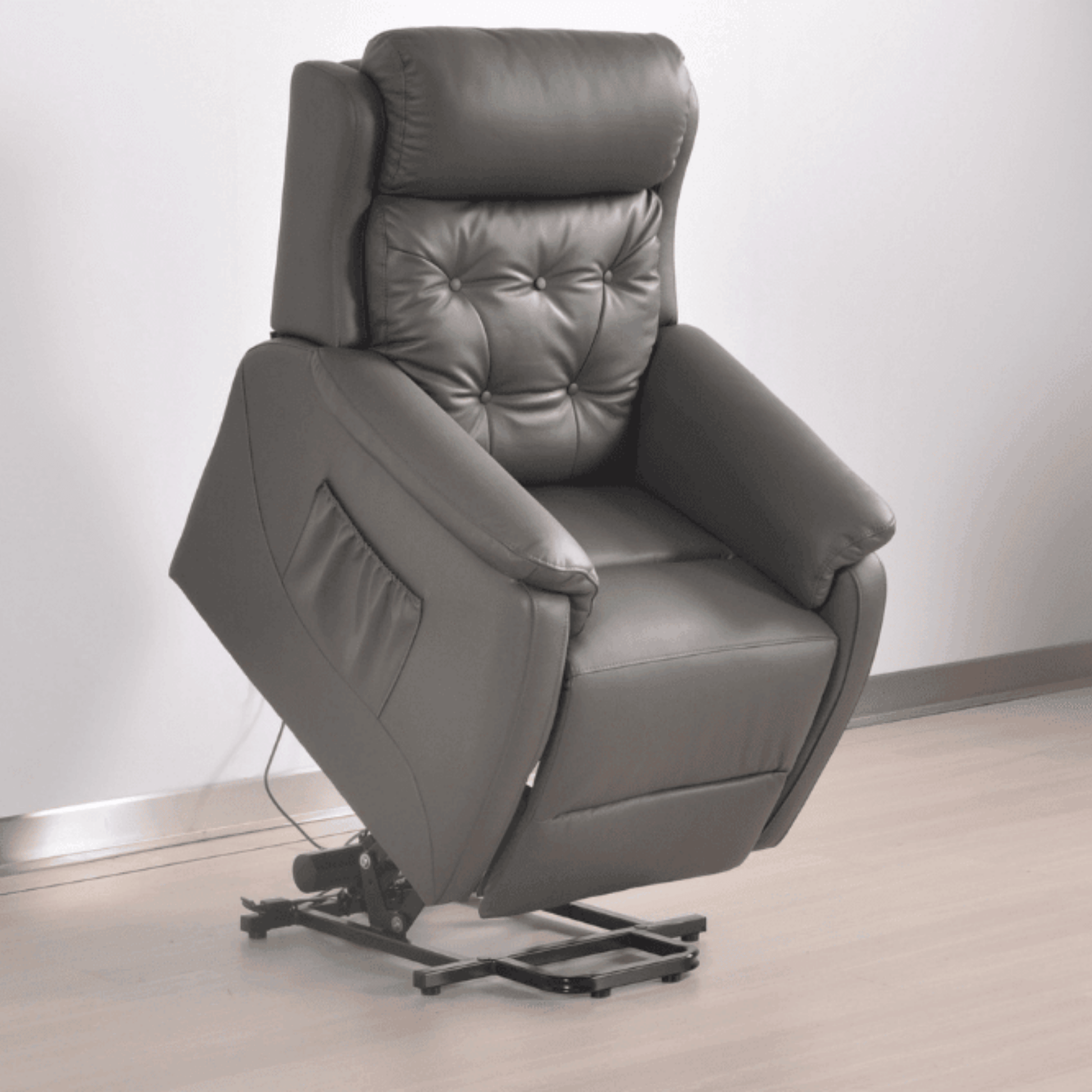 Gray leather recliner chair on a light wooden floor with a white wall background