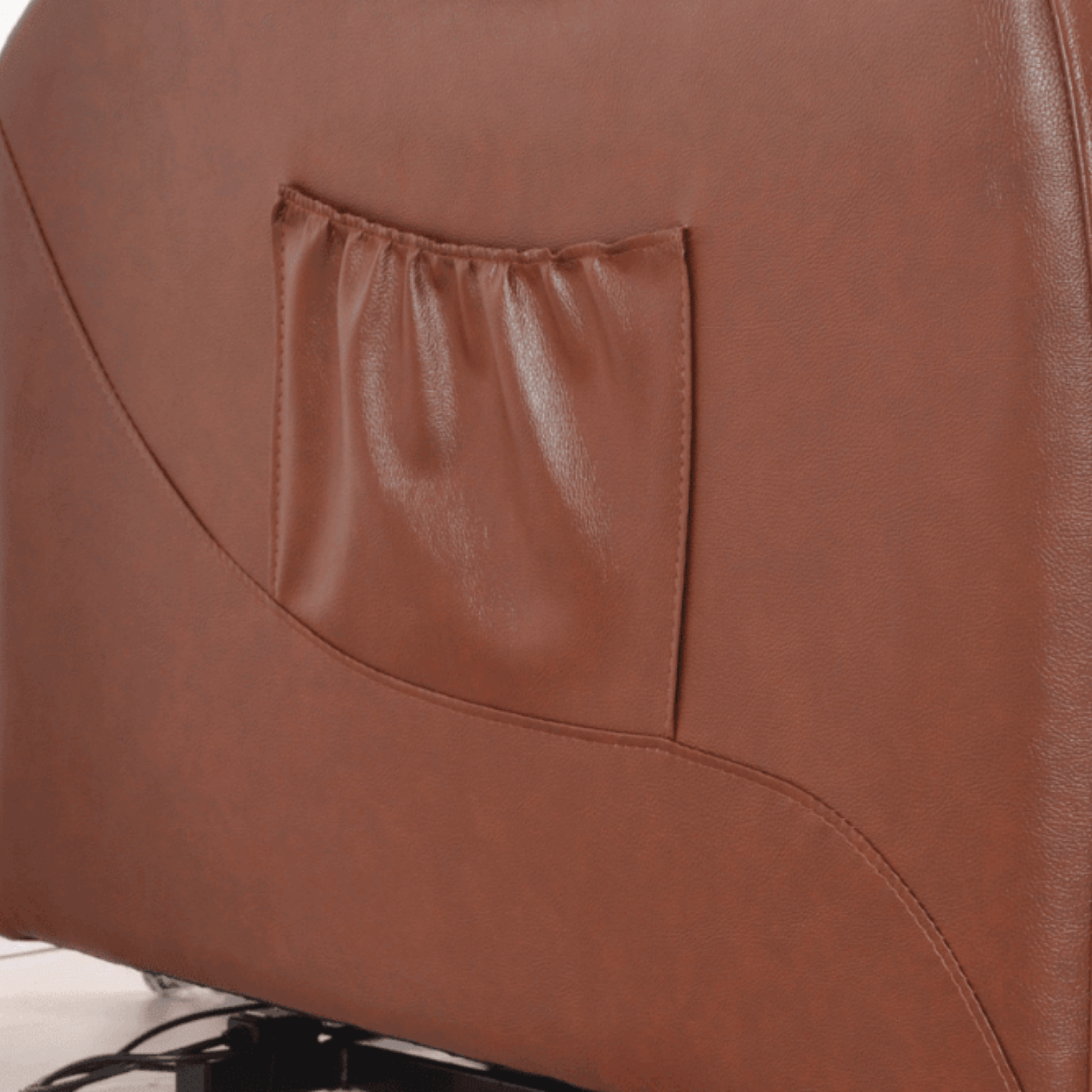 Close-up of a brown leather chair with a pocket on the backrest.