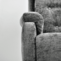Close-up of a textured gray fabric surface with a chair corner.