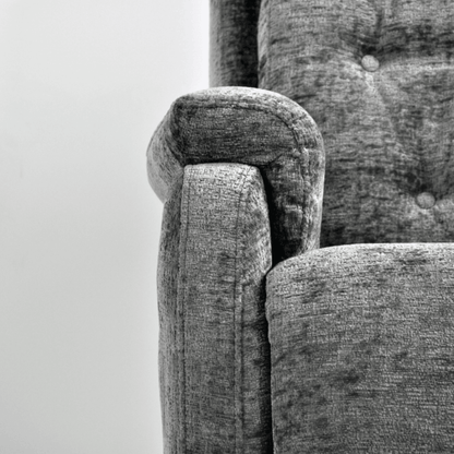 Close-up of a textured gray fabric surface with a chair corner.