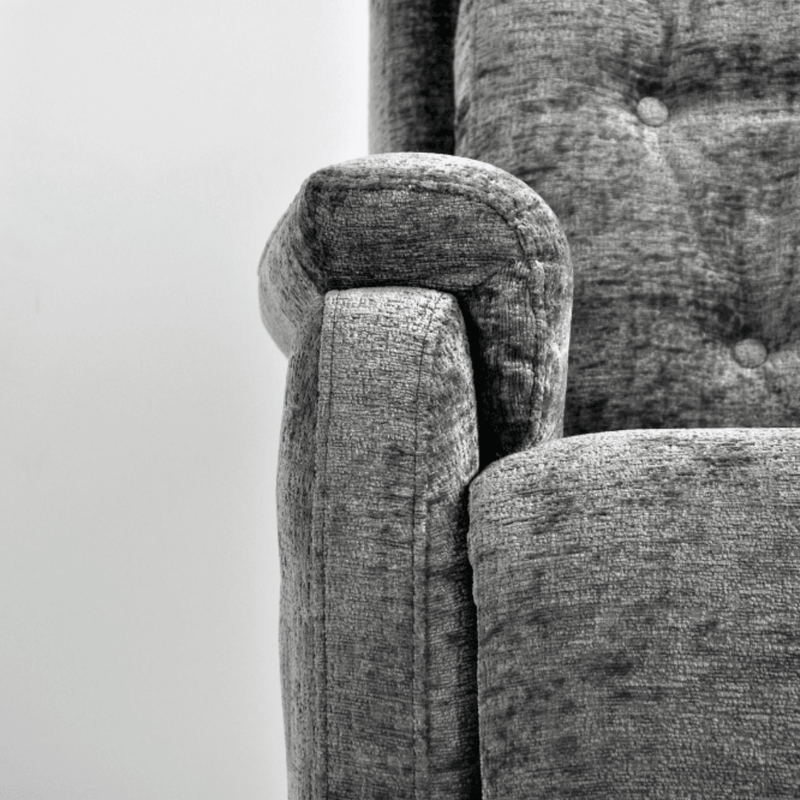 Close-up of a textured gray fabric surface with a chair corner.