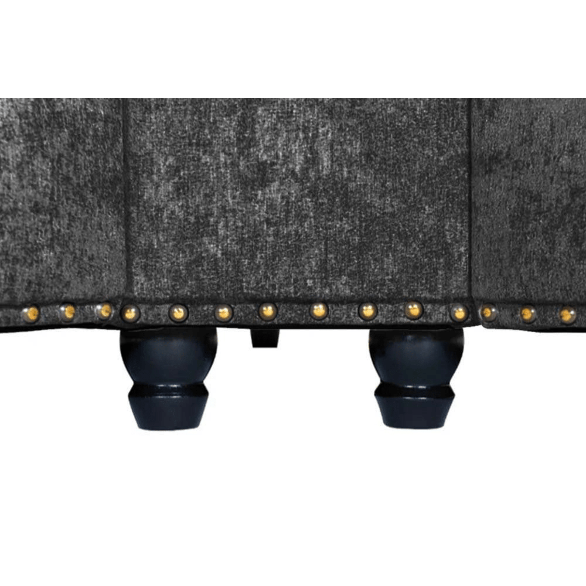 Close-up of a gray upholstered chair with black legs and gold studs on a white background