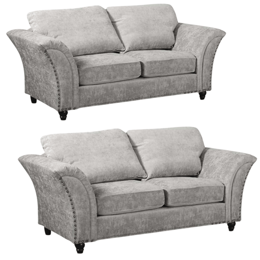 Two gray sofas with nailhead trim on a white background