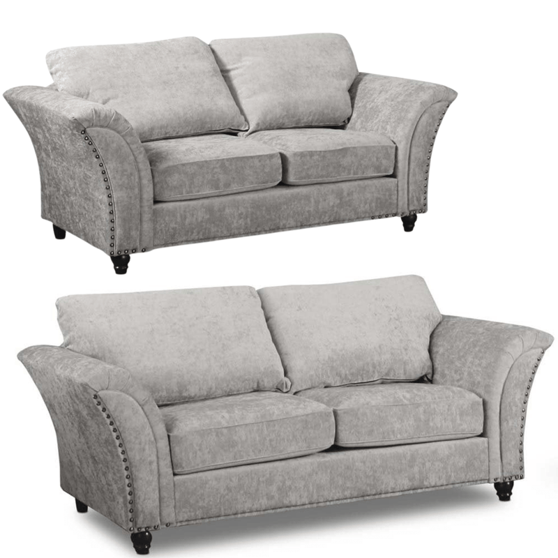 Two gray sofas with nailhead trim on a white background