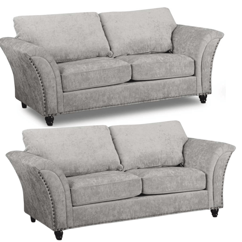 Two gray sofas with nailhead trim on a white background