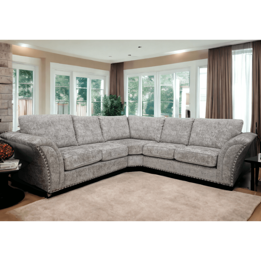 Gray sectional sofa in a living room with large windows and curtains.