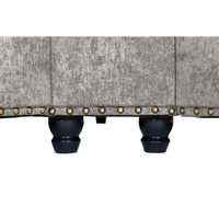 Close-up of a textured fabric surface with decorative studs on a white background