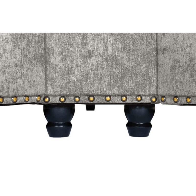 Close-up of a textured fabric surface with decorative studs on a white background