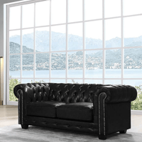 Black leather sofa in a room with large windows overlooking a scenic view.