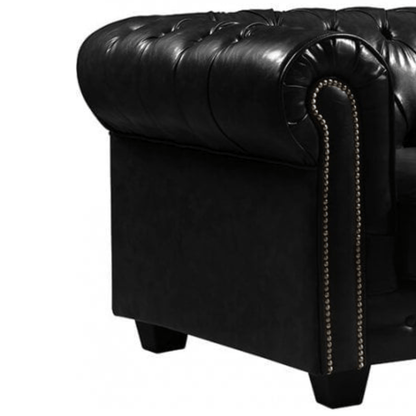 Close-up of a black leather armchair with tufted backrest and nailhead trim on a white background.