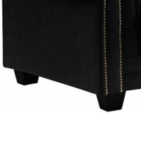 Black upholstered chair with nailhead trim on a white background