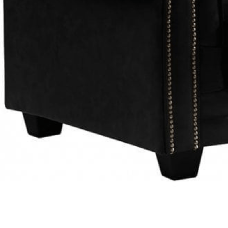 Black upholstered chair with nailhead trim on a white background