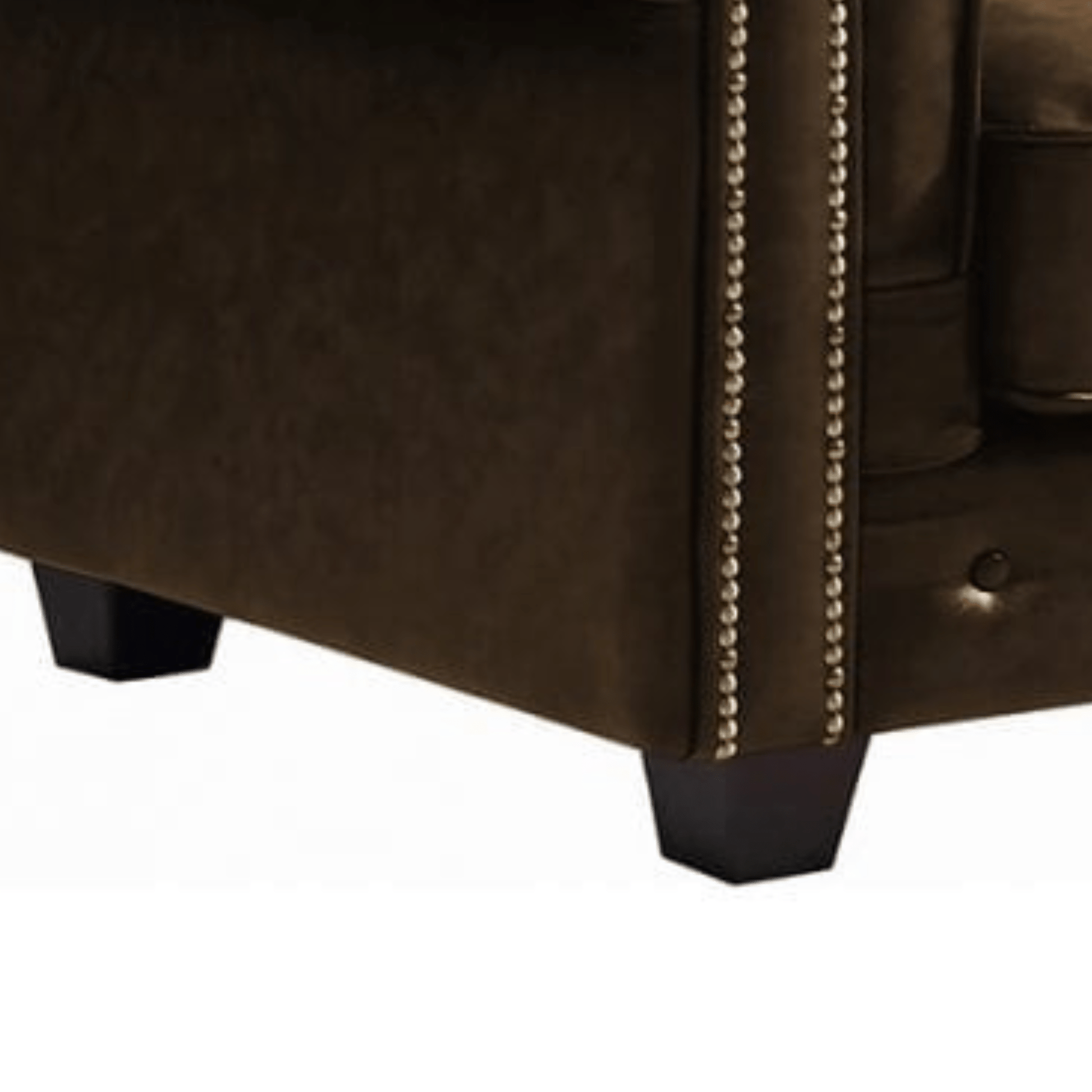 Close-up of a brown leather armchair with decorative nailhead trim on a white background
