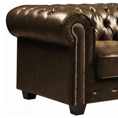 Brown leather sofa with tufted backrest and nailhead trim on a white background
