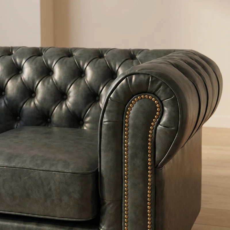Chesterfield Green Leather Antique 2 seater sofa close-up of the rolled arm and brass nailhead trim in a living room setting