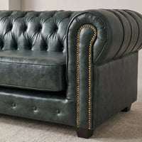 Chesterfield Green Leather Antique 3 seater sofa close-up of the rolled arm and brass nailhead trim in a living room setting