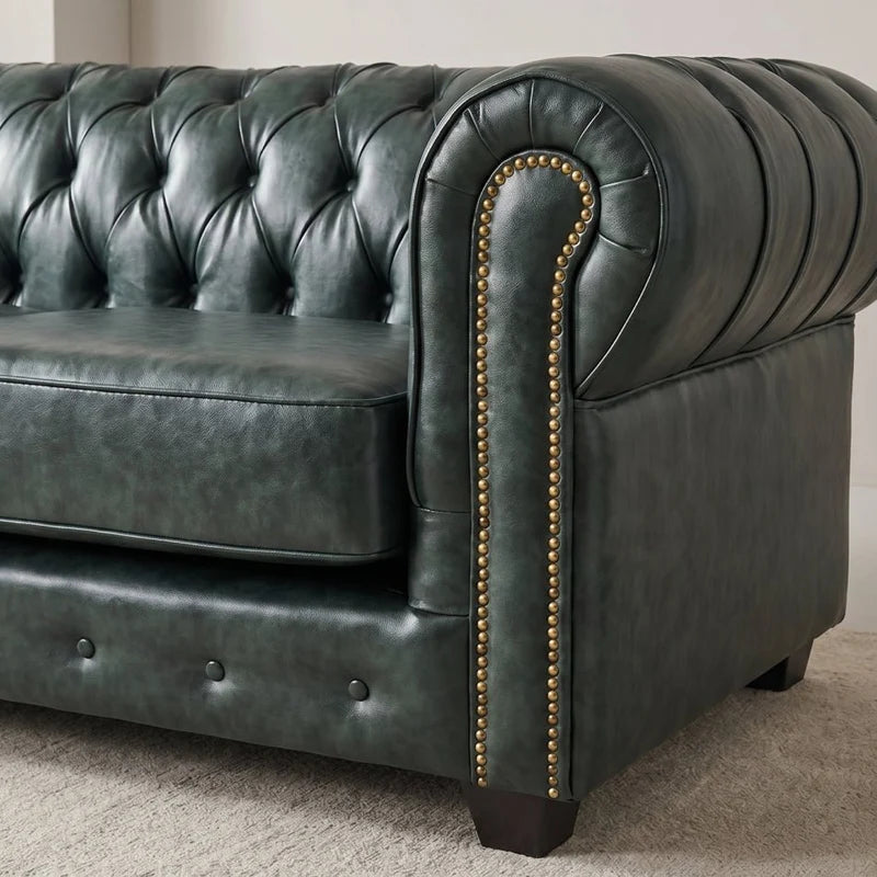 Chesterfield Green Leather Antique 3 seater sofa close-up of the rolled arm and brass nailhead trim in a living room setting