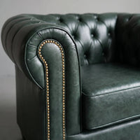 Chesterfield Green Leather Antique armchair close-up of button-tufted back and brass nailhead trim on the arm