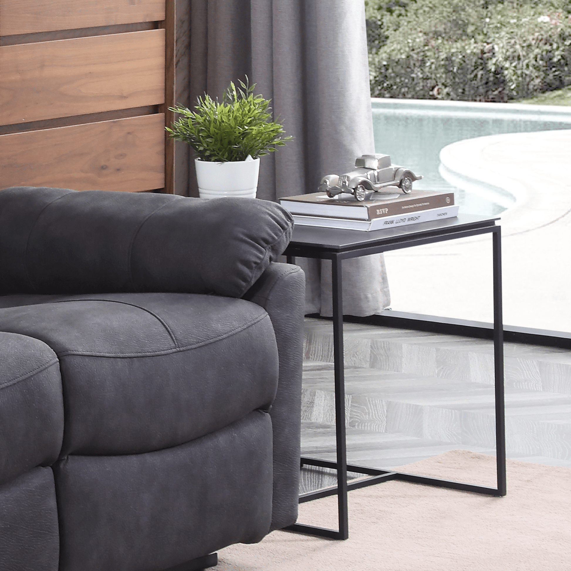 Grey sofa in a living room with a side table and decorative items.