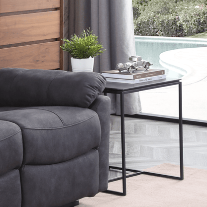 Grey sofa in a living room with a side table and decorative items.