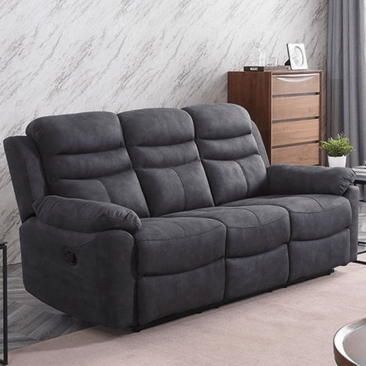 Grey sofa in a living room setting with a wooden cabinet and plant in the background.