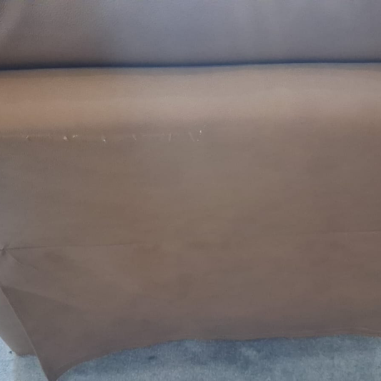 A close-up of a brown upholstered chair or sofa cushion, showing the fabric texture and a seam along the side.