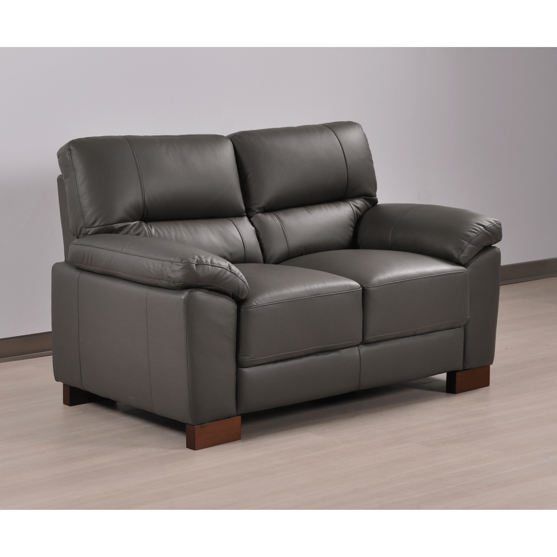 Angled view of the Dalmore Genuine Leather Grey 2-Seater Sofa in a styled room setting.