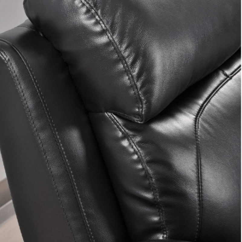 Close-up of a black leather armchair with visible stitching.