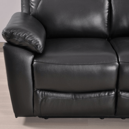 Close-up of a black leather recliner sofa on a light wooden floor.