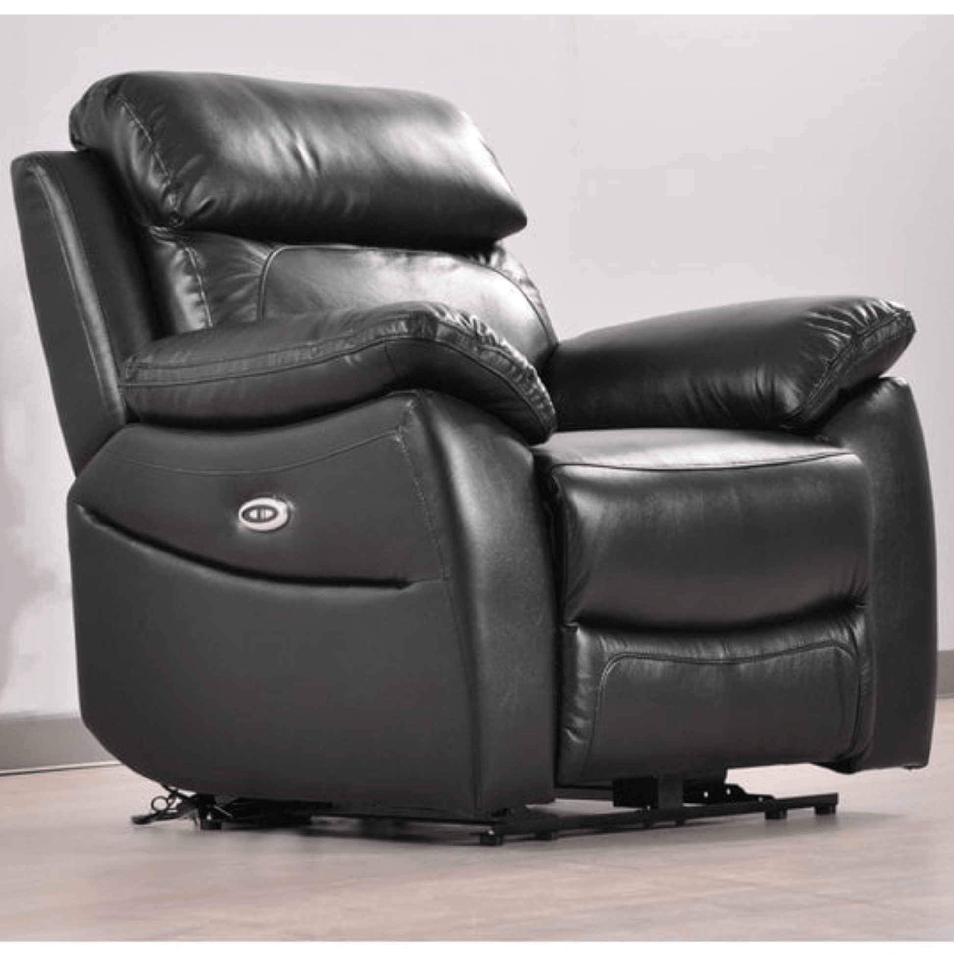 Black leather recliner chair on a wooden floor with a light gray wall background