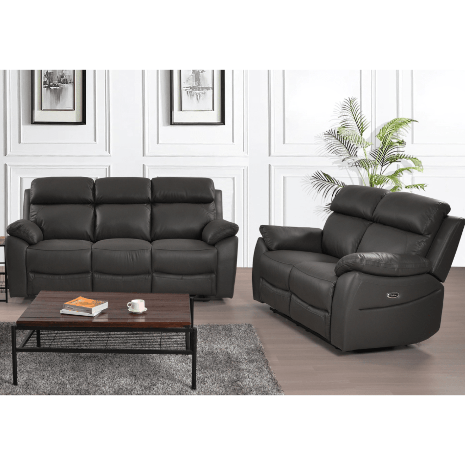 Black leather sofa set with a coffee table in a room with white walls and a plant.
