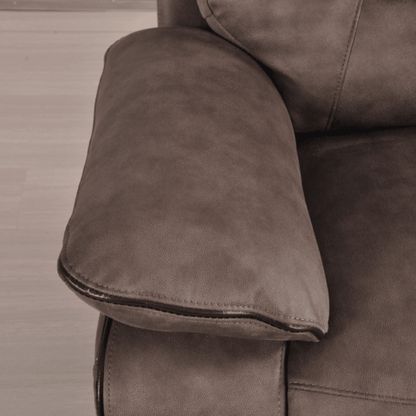 Close-up of a brown leather sofa armrest on a wooden floor.