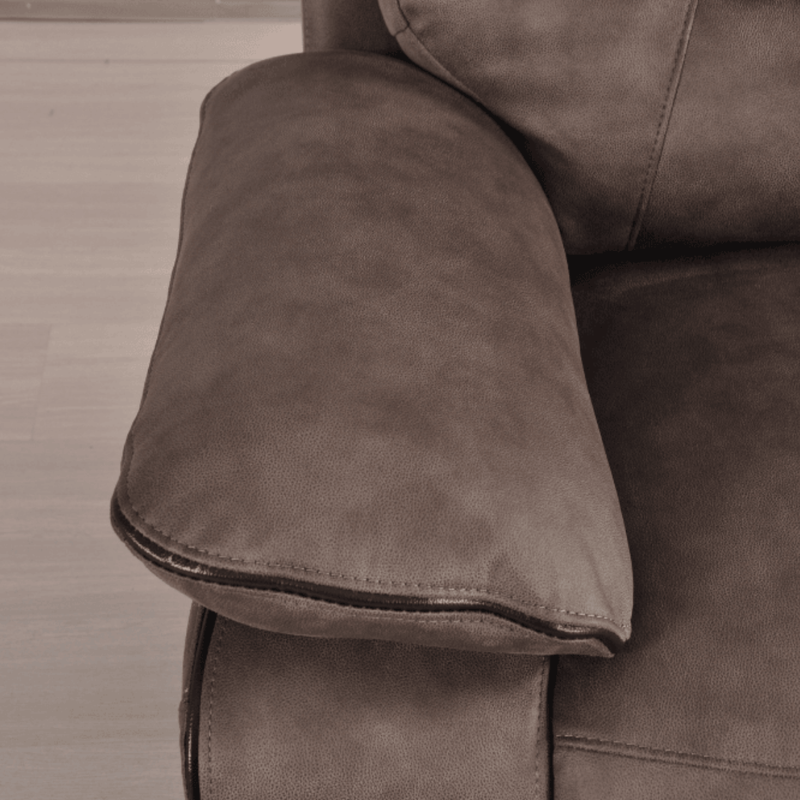 Close-up of a brown leather sofa armrest on a wooden floor.