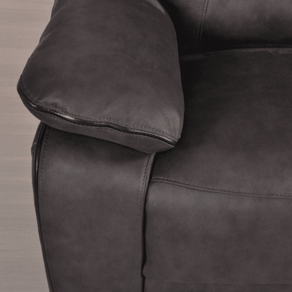 Close-up of a dark gray leather armchair with a wooden floor background