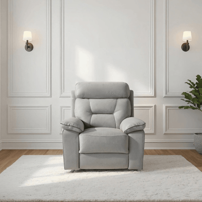 Gray recliner chair in a room with white walls and wooden flooring.