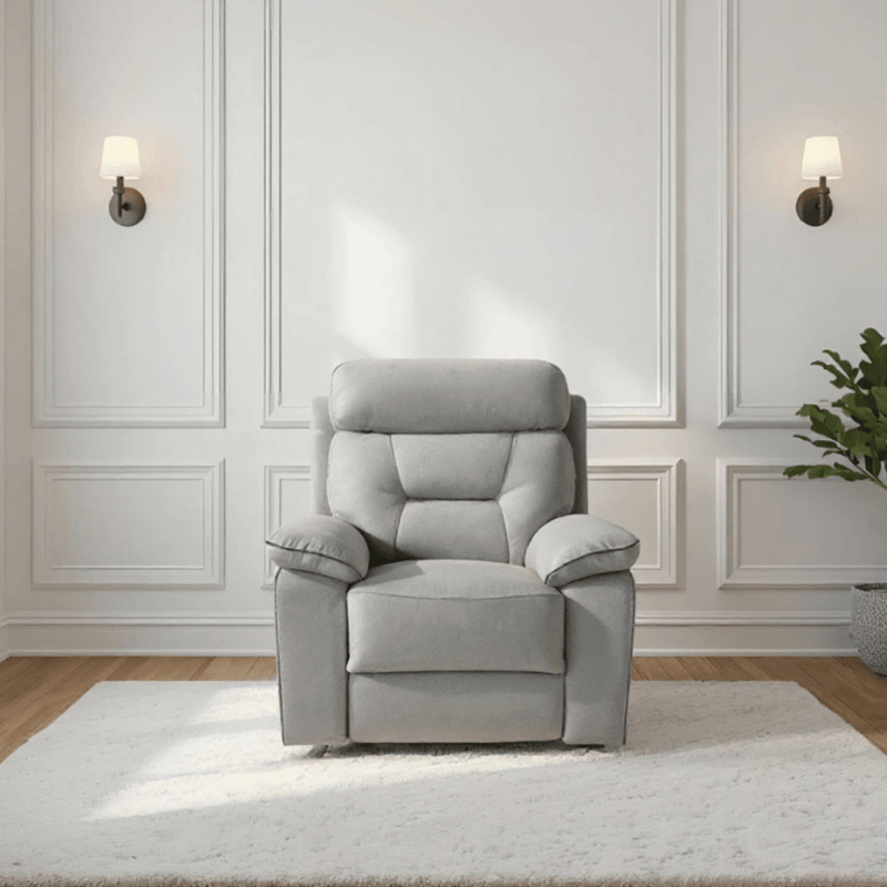 Gray recliner chair in a room with white walls and wooden flooring.