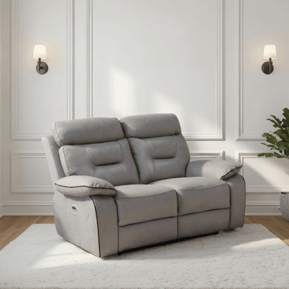 Gray recliner sofa in a room with white walls and wooden flooring.
