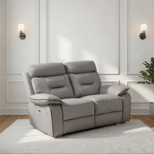 Gray recliner sofa in a room with white walls and wooden flooring.