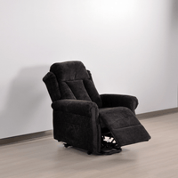 Black recliner chair in a room with a white wall and wooden floor.