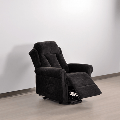 Black recliner chair in a room with a white wall and wooden floor.