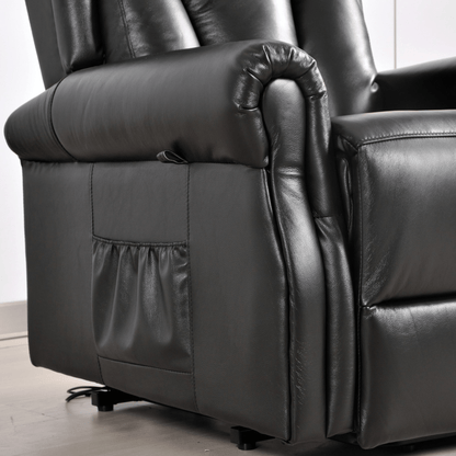 Close-up of a black leather recliner chair with power button on a light wooden floor.
