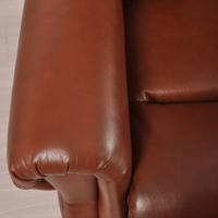 Close-up of brown leather armrests on a chair.