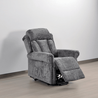 Gray recliner chair in a room with a white wall and wooden floor.